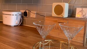 Een keuken met een moderne toaster, een radio en twee glazen kristallen glazen op een houten aanrecht.