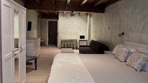 A bedroom with a large bed, a desk, and a wardrobe. - CASA PEQUE (Laguardia)