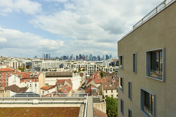 A cityscape with modern buildings, a mix of residential and commercial structures, and a clear sky. - Zenao Appart'hôtels Suresnes (Suresnes)