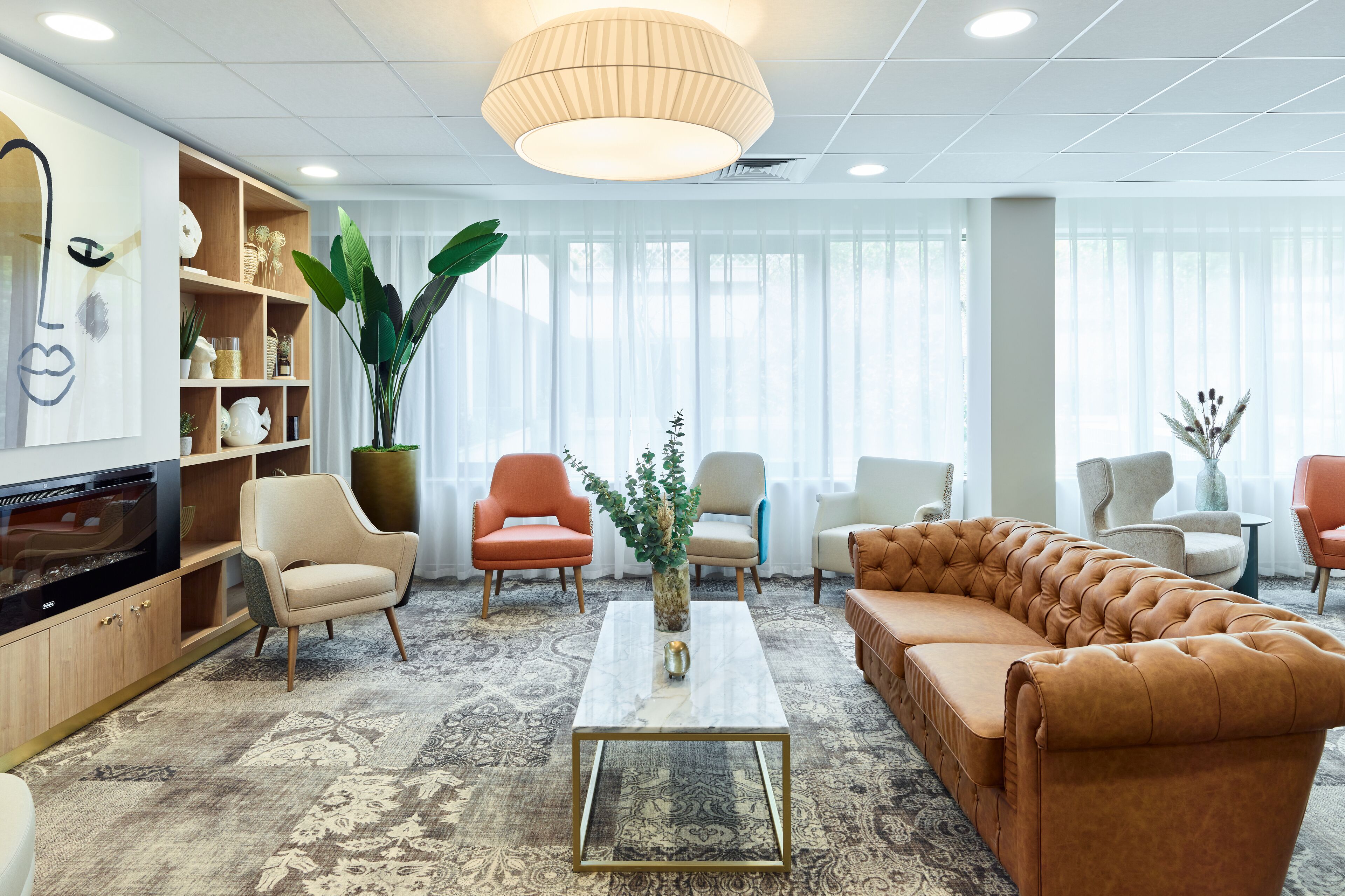 Een moderne woonkamer met een bank, fauteuils, een salontafel en een televisie.