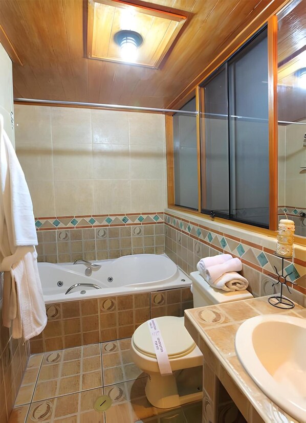 A compact bathroom with a bathtub, toilet, and sink. - El Puma (Cusco)