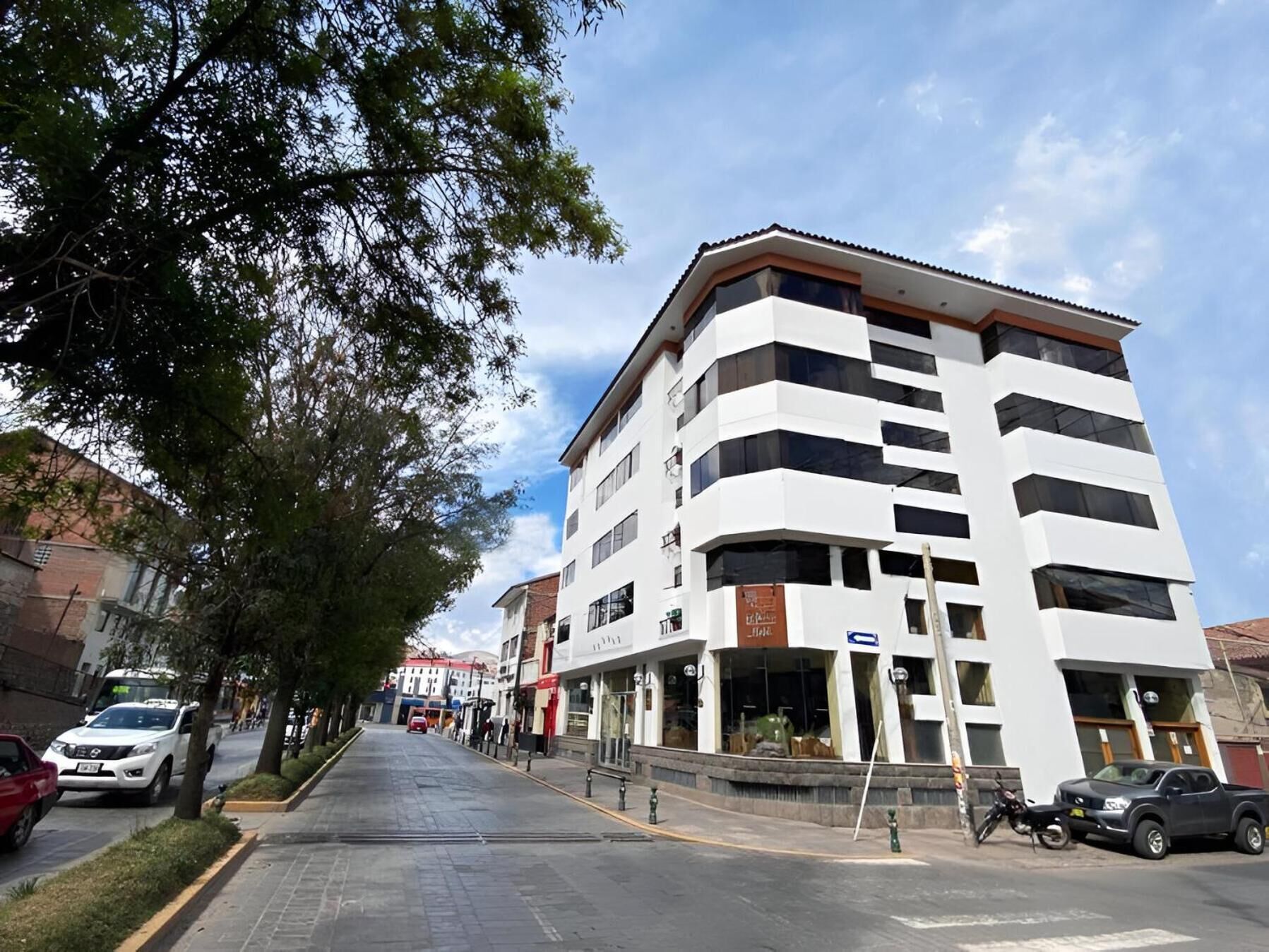 Um edifício de vários andares com design moderno, destacando uma entrada de canto e grandes janelas.