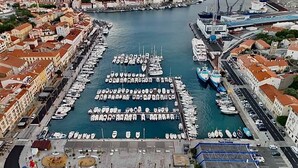 Ein Yachthafen mit in Reihen liegenden Booten, umgeben von Gebäuden mit roten Dächern.