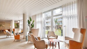A modern hotel lobby with a spacious layout, large windows, and a variety of seating options. - Zenao Appart'hôtels Montreuil (Montreuil)