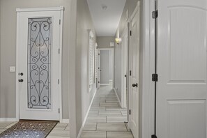 Stylish hallway with doors leading to rooms and a decorative glass door.