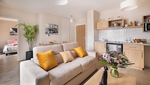 A modern apartment with a living room, kitchen, and dining area. - Zenao Appart’hôtels Le Raincy (Le Raincy)
