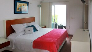 Ein Schlafzimmer mit Bett, Nachttisch, Fenster und Tür.