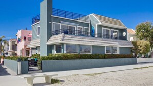 Un bâtiment moderne à deux étages, doté d’un balcon, de grandes fenêtres et d’un toit plat.