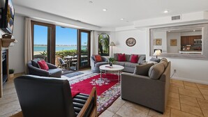 A living room with a red rug, two sofas, a coffee table, and a TV.