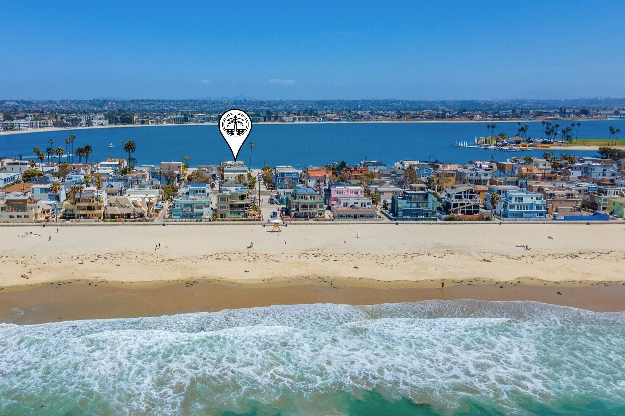 A coastal town with a beach, ocean, and a marina.