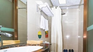 Une salle de bain avec un lavabo en marbre, des toilettes blanches, une douche avec une porte en verre et un porte-serviettes avec des serviettes blanches.