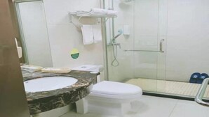 Une salle de bain avec une douche à parois de verre, un lavabo blanc et des toilettes.