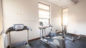 Une salle de sport équipée de tapis de course, de vélos elliptiques et de matériel de musculation.