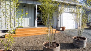 A house with a porch, a garage, and potted bamboo plants. - Relax and unwind in a tranquil space one block from the beach (Manzanita)