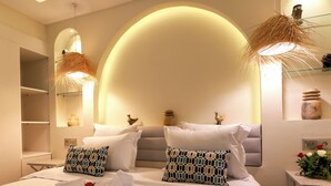 Een moderne hotelkamer met een groot bed, twee nachtkastjes, een spiegel en een uniek plafondontwerp.