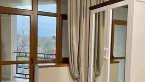 A room with a large window, a wardrobe, and a view of a building outside. - Villa ACAEM #3 (Chișinău)