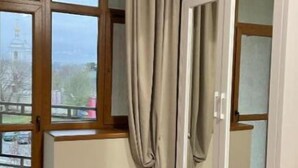 A room with a large window, a wardrobe, and a view of a building outside. - Villa ACAEM #5 (Chișinău)