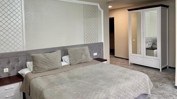 A bedroom with a bed, nightstands, a wardrobe, and a mirrored closet. - Villa ACAEM #5 (Chișinău)