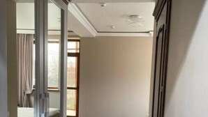 A hallway with a sliding door leading to a bedroom with a bed and a window. - Villa ACAEM #9 (Chișinău)