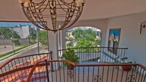 A multi-level interior with a spiral staircase, a chandelier, and a view of the outdoors. - Hotel Pez Vela (Manzanillo)