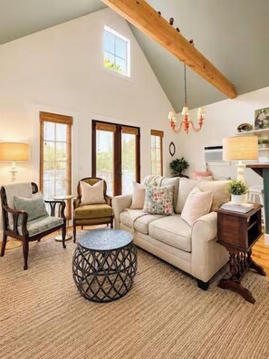A spacious living room with a high ceiling, a round coffee table, a sofa, and a chair. - The Cottage, Firepit+ Animals, VelvetDitchVillas (Oxford)