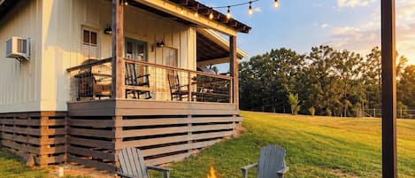 A house with a covered porch, outdoor seating, and a fire pit.