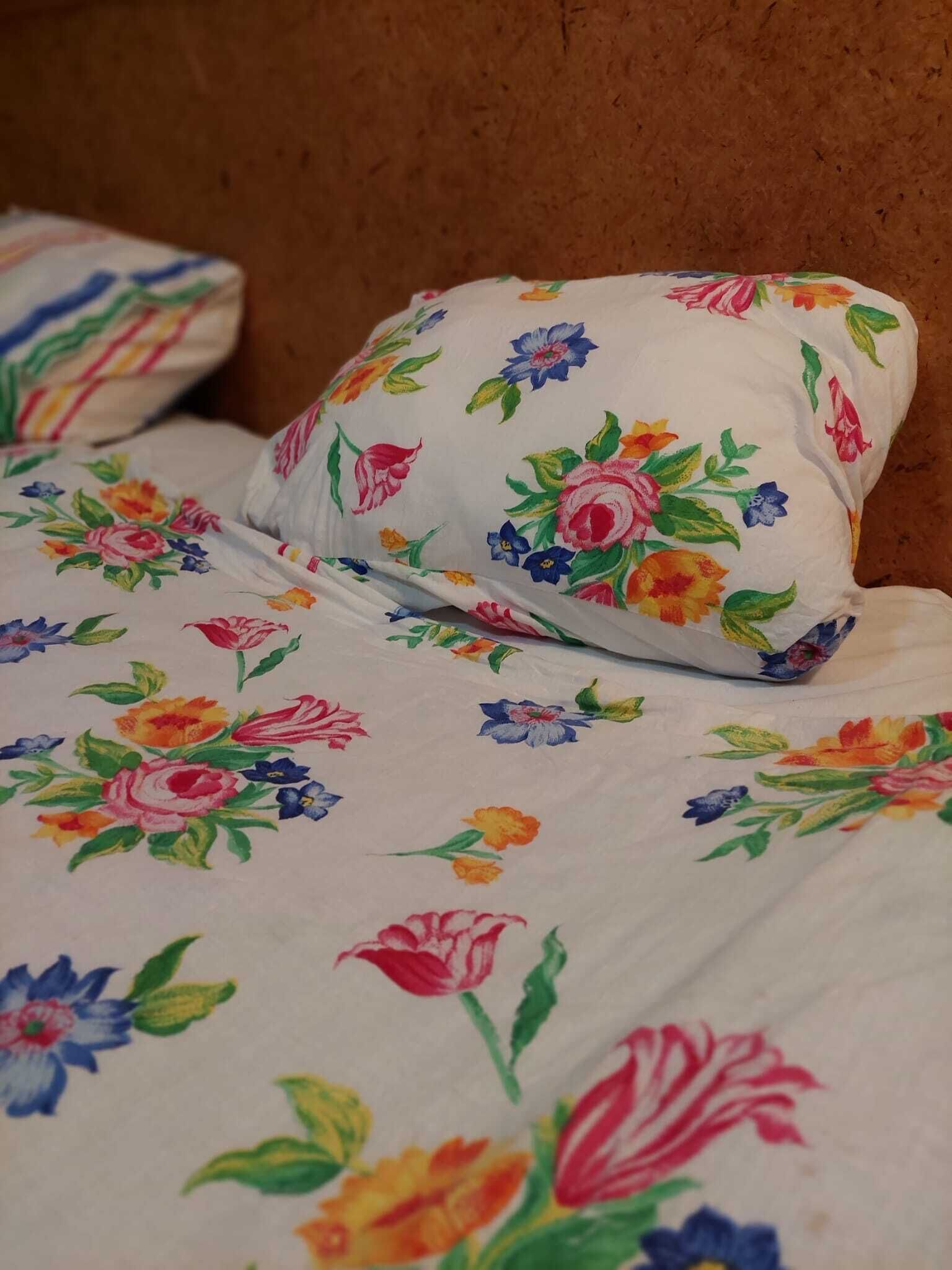 A bed with floral-patterned bedding and pillows.