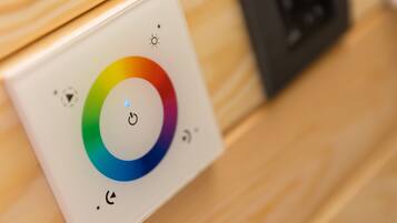 Panell de control amb una roda de colors i un botó d'encesa.