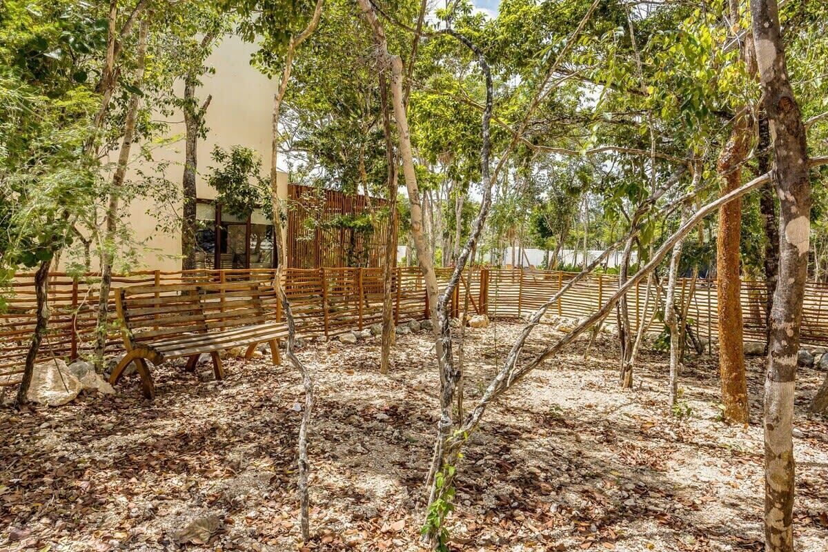 A courtyard with wooden benches and a bamboo fence.
