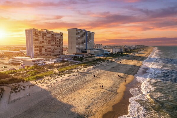 Ein Küstenhotel mit mehreren Hochhäusern, einem Strand und Blick auf den Ozean.