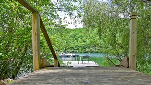 Un muelle de madera con un banco que da a un lago y un embarcadero.