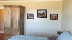 A bedroom with a bed, a wardrobe, and three framed pictures on the wall. - Bryce Canyon, Zion National Park A Six K (Panguitch)