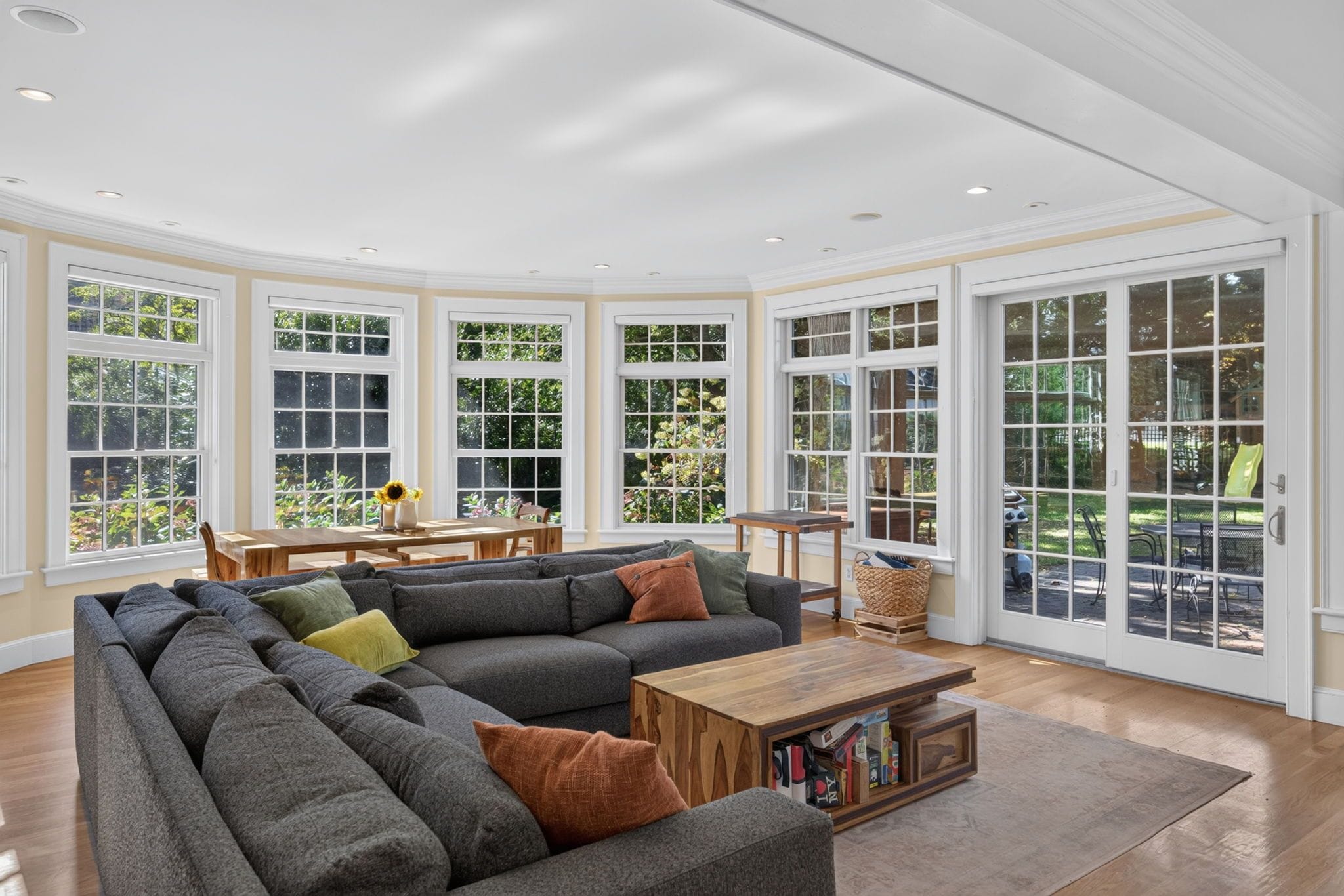 A spacious living room with a sectional sofa, a coffee table, and a dining area with a table and chairs.