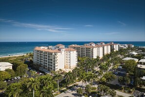 A beachfront hotel with multiple buildings, a parking lot, and palm trees. - Marriott Ocean Pointe, Oceanside, Kitchen, Access to Resort Amenities (Palm Beach Shores)