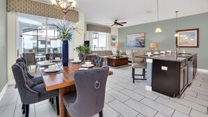 A spacious living area with a dining table, chairs, and a kitchen island. - Beautiful Town Home with Splash Pool-4804CS (Kissimmee)