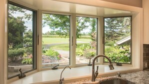 Eine Küche mit einem großen Fenster mit Blick auf einen Garten.