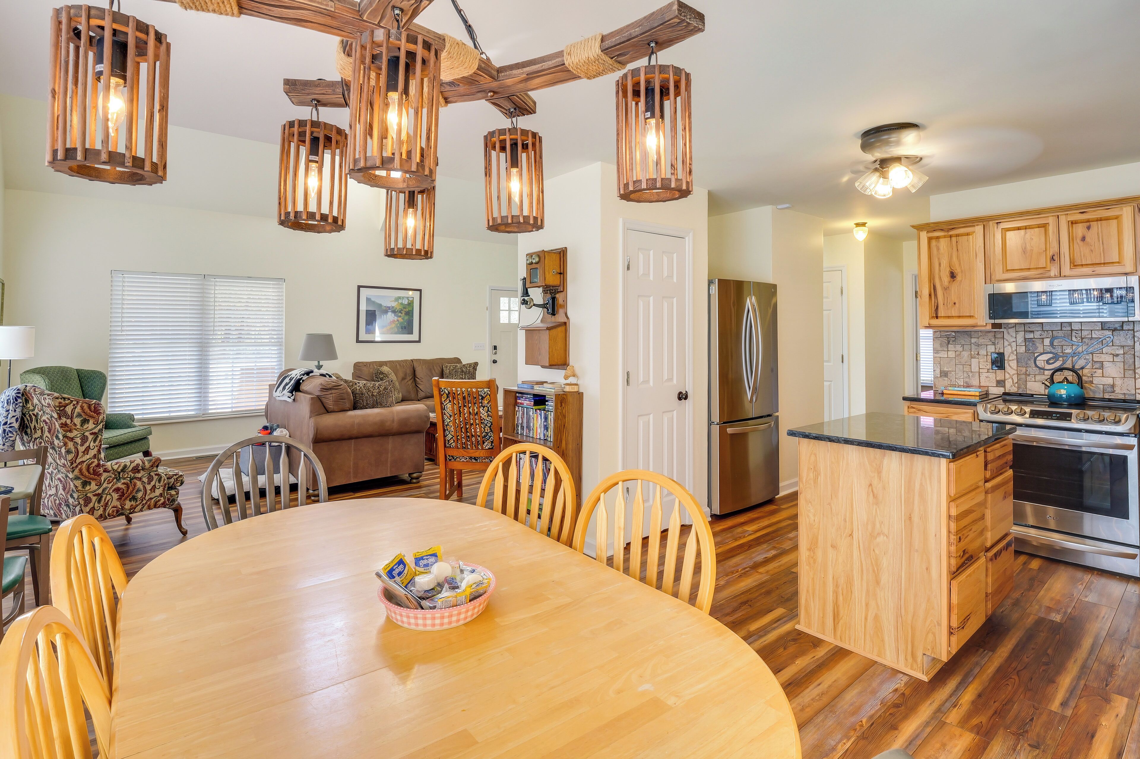 Une cuisine moderne avec des meubles en bois, un îlot central et un coin repas comprenant une table ronde et des chaises.