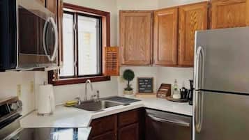 Een magnetron, een oven, een vaatwasser, kookgerei, borden en bestek