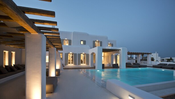 A modern resort with a pool, outdoor seating, and a covered area. - ISholidays Mykonos Villa Zircon (Tourlos)
