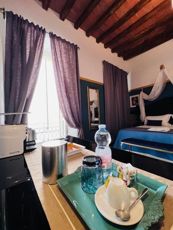 Una habitación de hotel con una cama, una mesita de noche con una botella de agua, una taza y una bandeja con una cuchara.