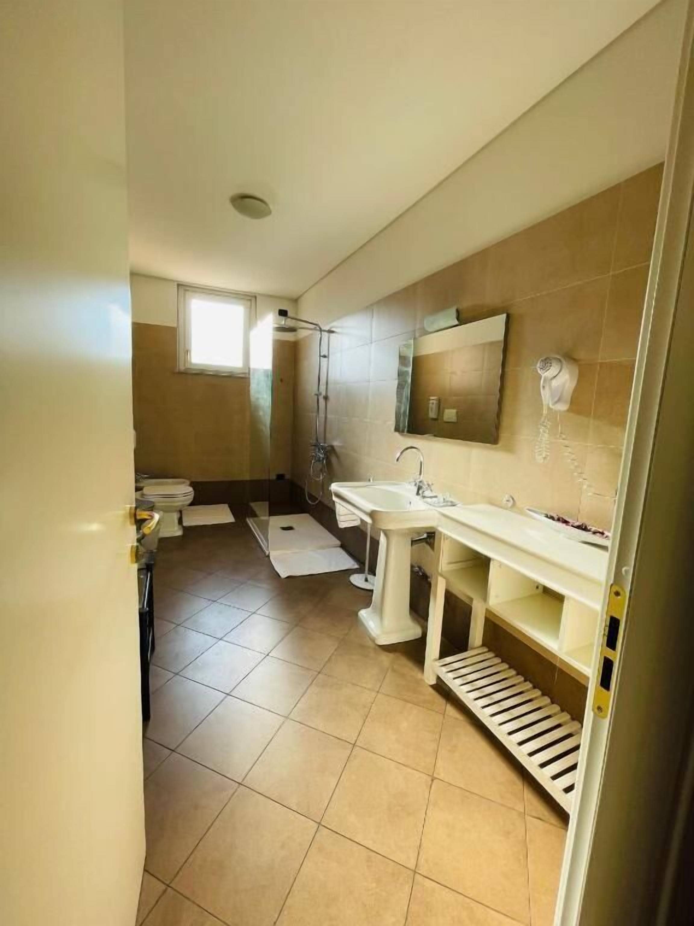 Un baño con ducha, inodoro y lavabo.