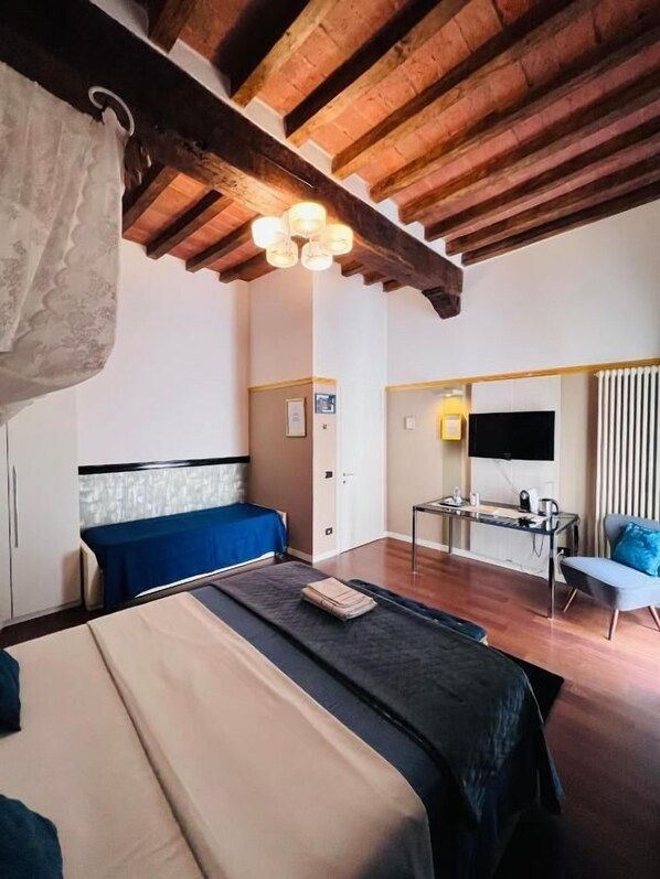 A bedroom with a bed, a desk, and a chair. - Domus San Martino (Piacenza)