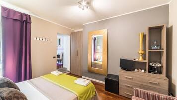 Una habitación de hotel con cama, cómoda, espejo y televisión.