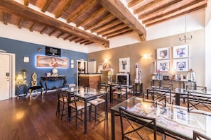 Un espace repas agrémenté de poutres en bois, de tables avec des magazines et de tableaux encadrés aux murs.