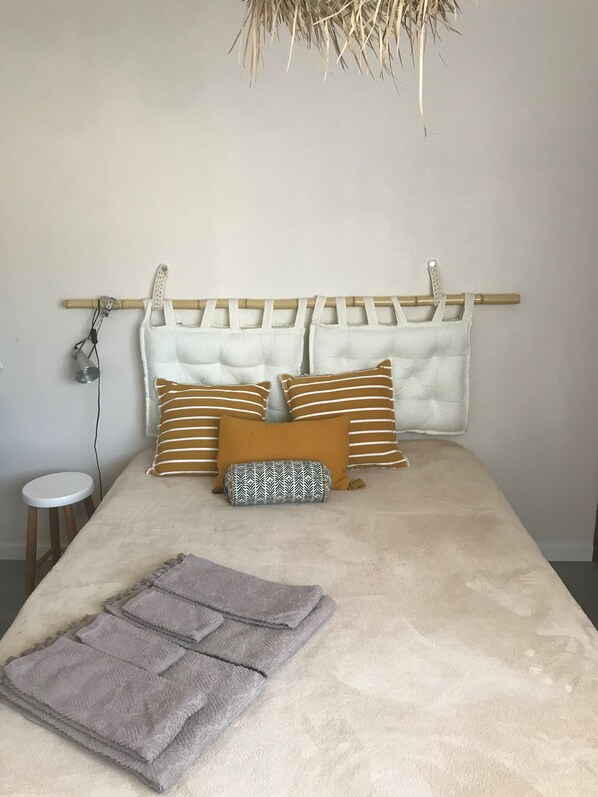 A bed with a headboard, pillows, and a blanket.