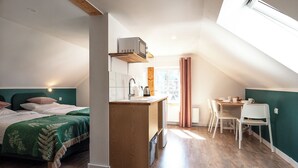A compact, modern room with a loft-style bed, a kitchenette, and a dining area. - Willa Dąbrówka (Karpacz)