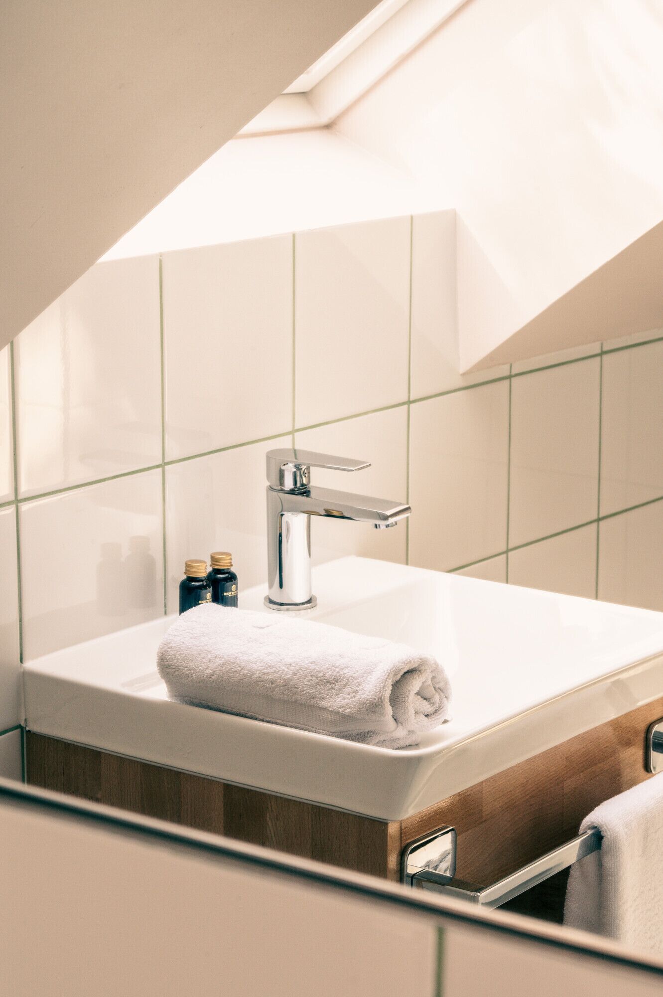 Une salle de bain moderne avec un lavabo blanc, un robinet chromé et une serviette posée sur le comptoir.