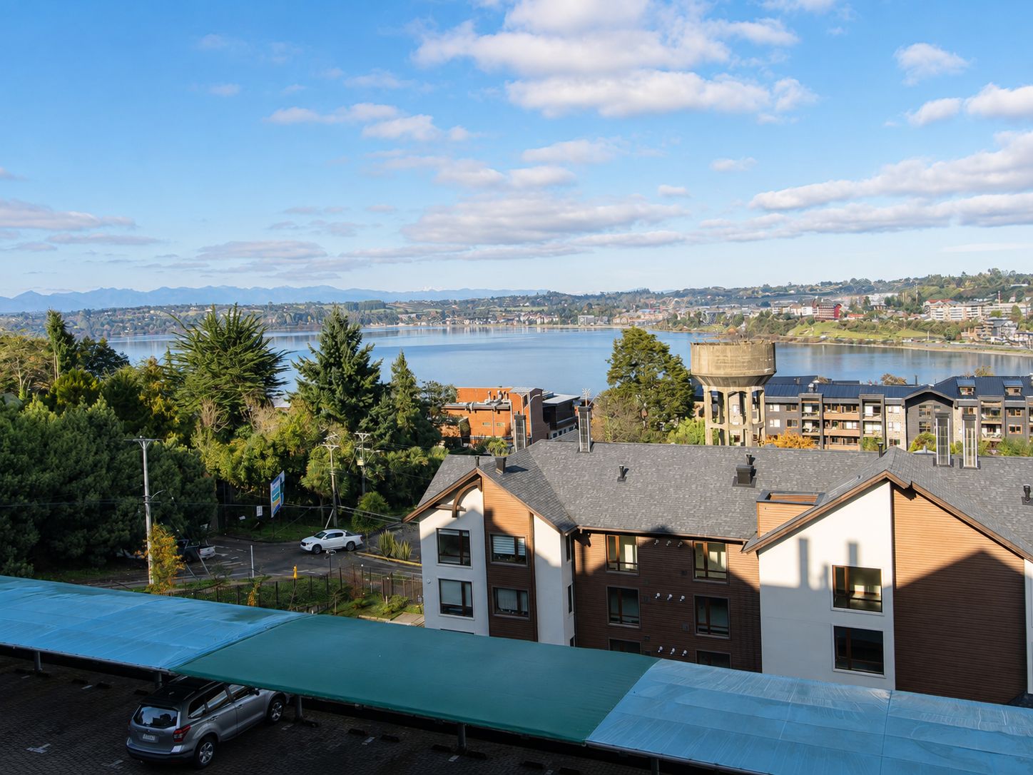 Un quartier résidentiel offrant une vue sur un lac et des montagnes au loin.