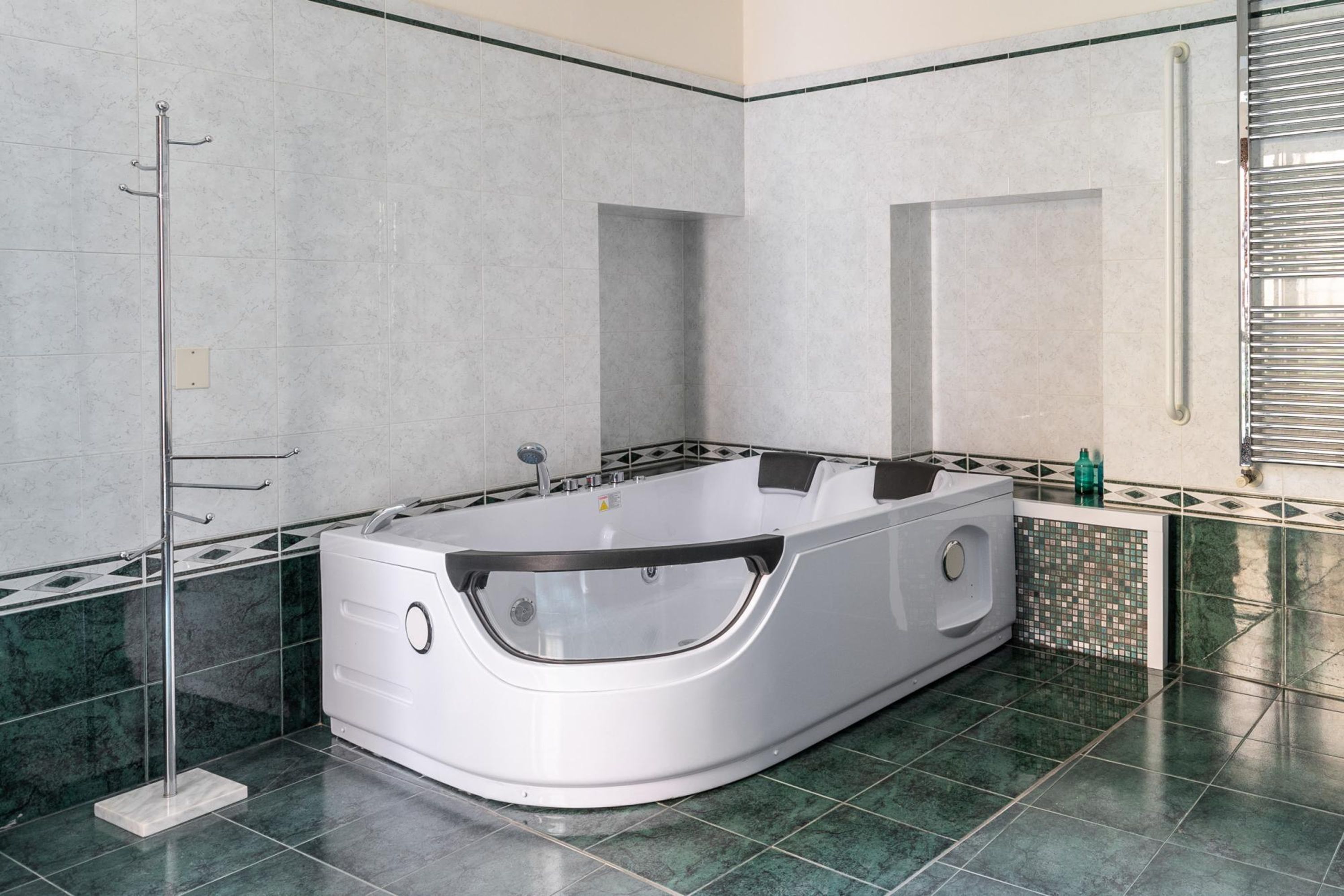 Un baño moderno con una bañera independiente, cabina de ducha con paredes de vidrio y suelo de baldosas.