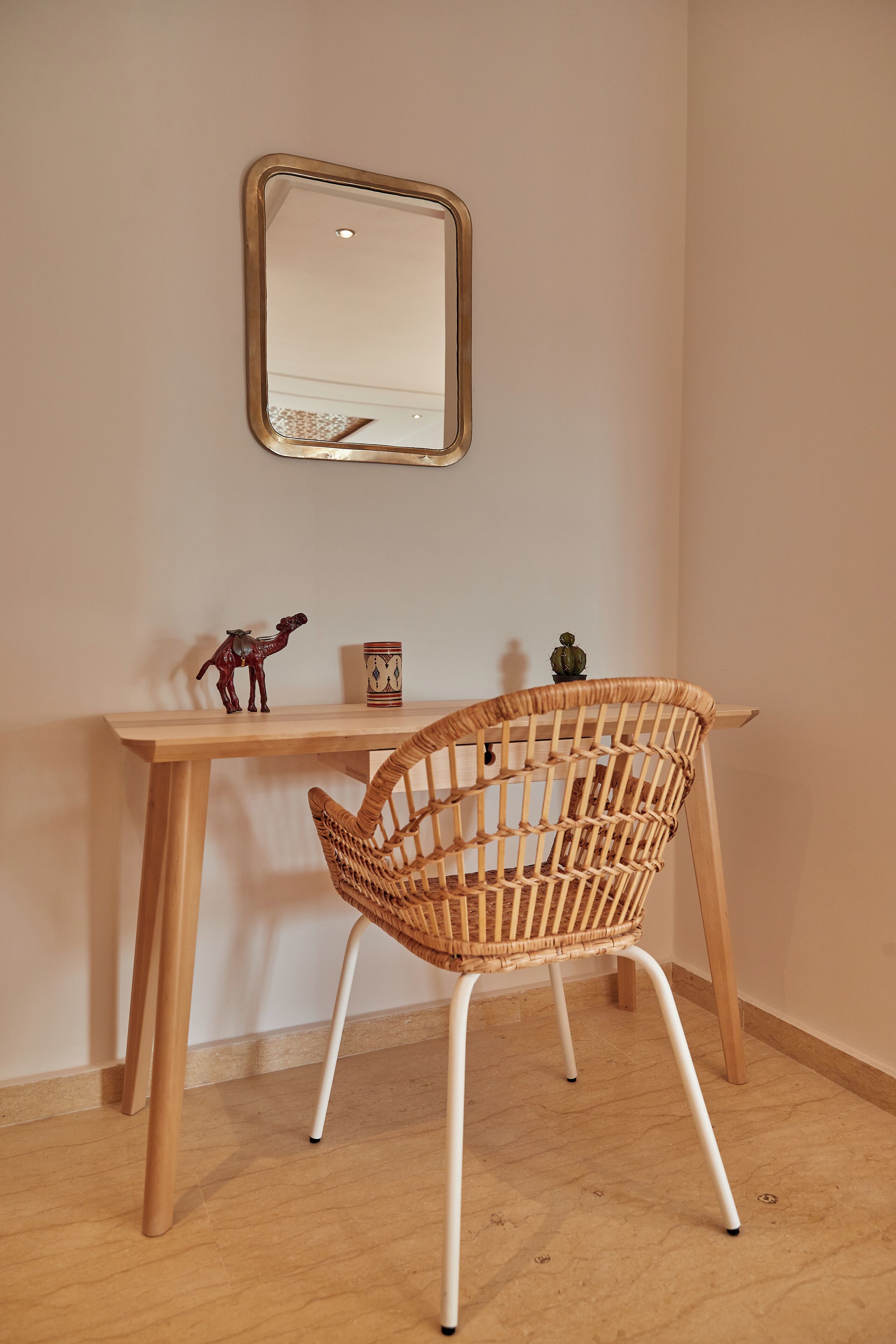 A corner desk with a woven chair, a small figurine, and a decorative item on the wall.